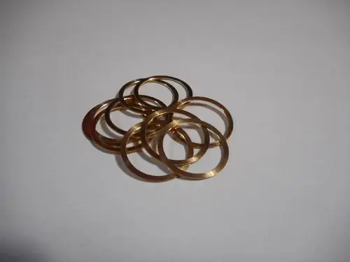 Goldfarbene Distanzringe von Remeha in einer Anordnung, die einen Stapel aus mehreren Ringen zeigt. Die Ringe sind dünn und haben eine kreisförmige Form.